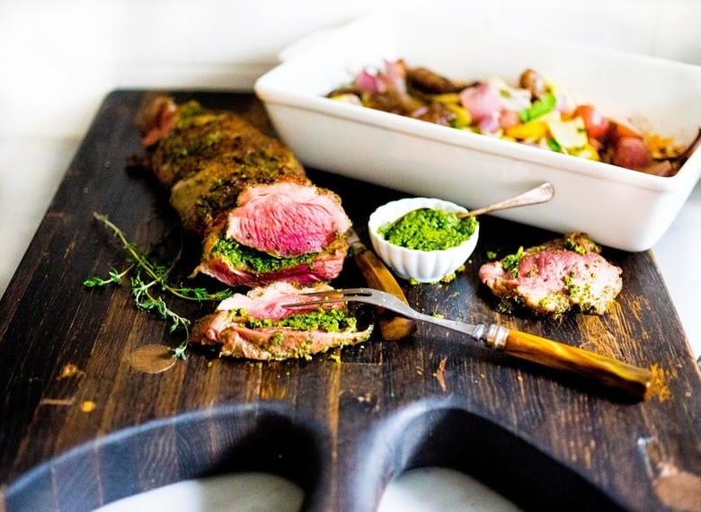 Herb-Crusted, Stuffed Leg of Lamb with flavorful Mint Gremolata, a step by step guide to an amazingly delicious holiday main course, baked over roasted vegetables.  #legoflamb #lamb #lambleg #easterdinner #easter #stuffedlamb #lambrecipes 