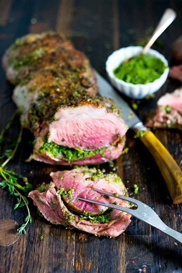 How to make the most delicious, Slow-Roasted Leg of Lamb with a flavorful herb crust and filling, roasted over vegetables and served with Mint Gremolata. A special dinner is worthy of your holiday table. #legoflamb #lamb #lambleg #easterdinner #easter #stuffedlamb #lambrecipes #lambroast #roastlegoflamb