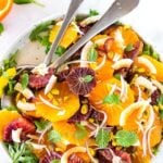 This Moroccan-inspired Citrus Salad with dates, arugula, mint, pistachios, and toasted coconut is dressed in the most flavorful Citrus Shallot Vinaigrette. It's deliciously juicy and vegan! #citrussalad #orangesalad