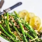 Simple Roasted Asparagus baked in the oven with lemon, garlic and olive oil. Can be made in 20 minutes! An easy vegan side dish, perfect for spring. #roastedasparagus