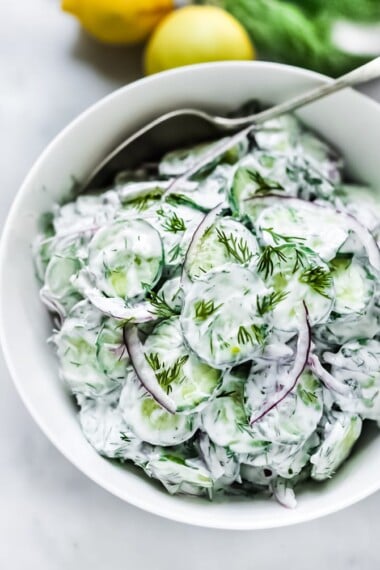 Turkish-inspired Creamy Cucumber Salad made with dill and mint in a creamy yogurt dressing. Cool and refreshing this herby lemony summer salad pairs well with grilled meats or fish, or falafels! 
