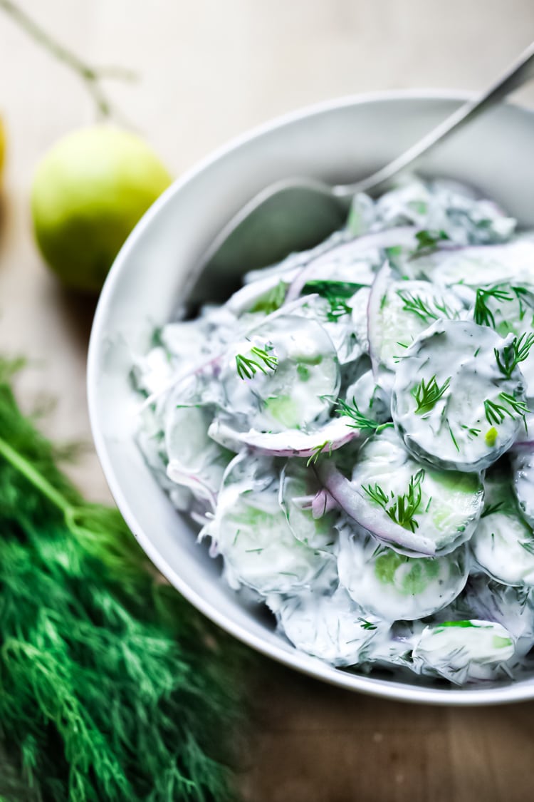 Turkish-inspired Creamy Cucumber Salad made with dill and mint in a creamy yogurt dressing. Cool and refreshing this herby lemony summer salad pairs well with grilled meats or fish, or falafels! 