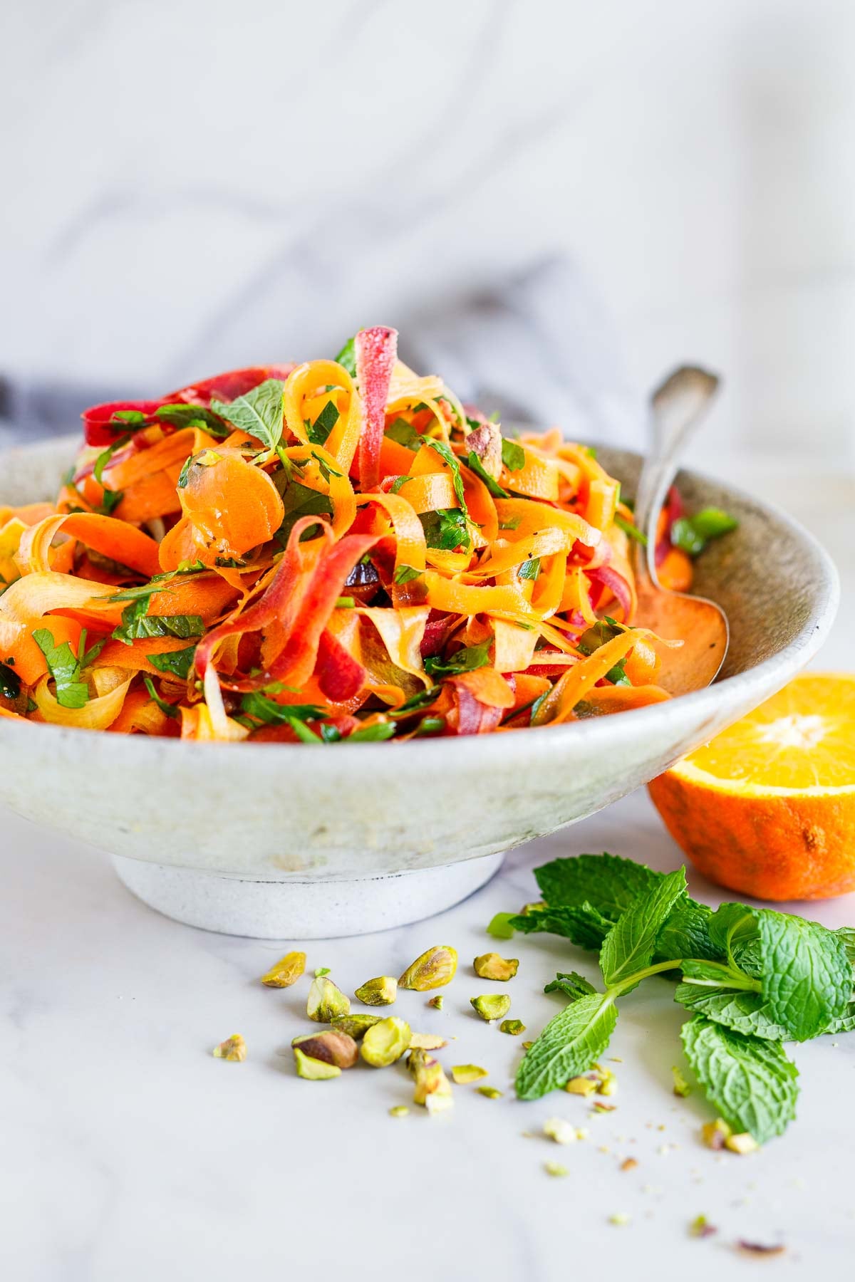 This Moroccan carrot salad is a light and refreshing side dish. Made with fresh carrots, herbs, pistachio nuts, dates, and an orange-cumin dressing. Vegan.