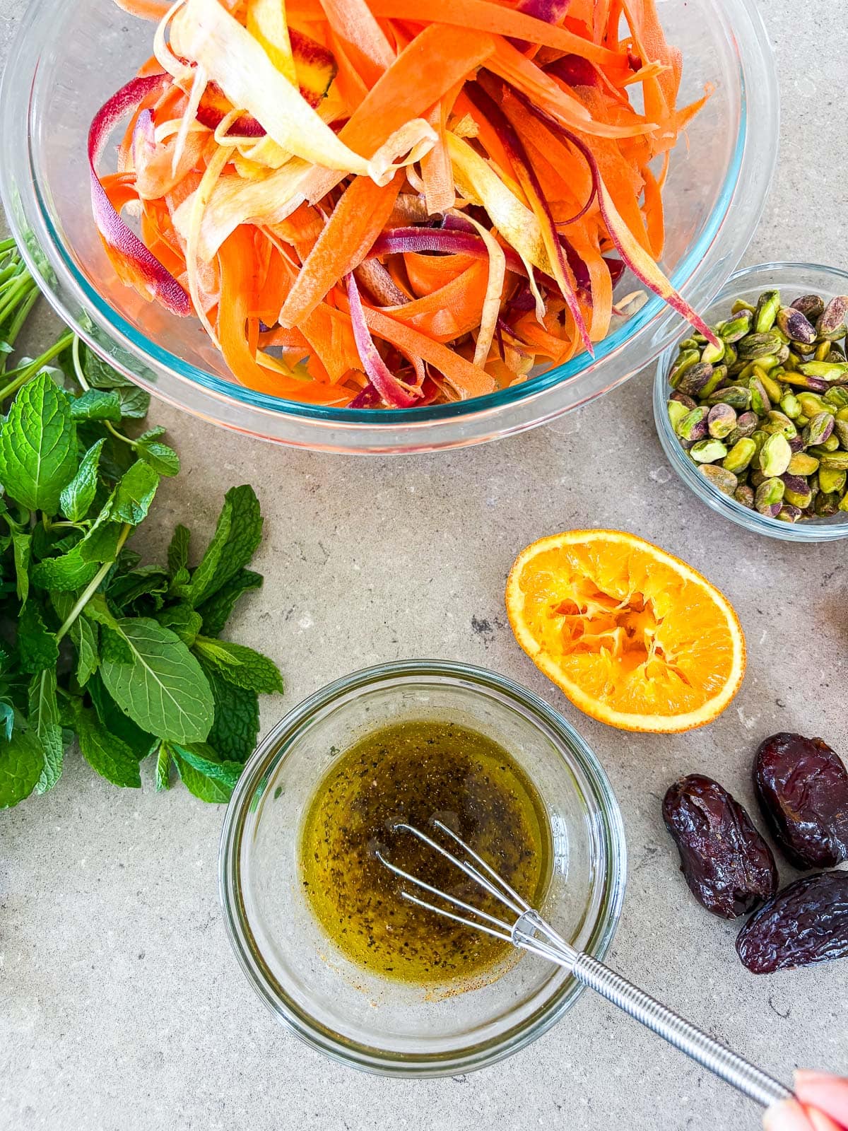 whisking the carrot salad dressing in a small bowl.
