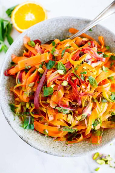This Moroccan carrot salad is a light and refreshing side dish. Made with fresh carrots, herbs, pistachio nuts, dates, and an orange-cumin dressing. Vegan.