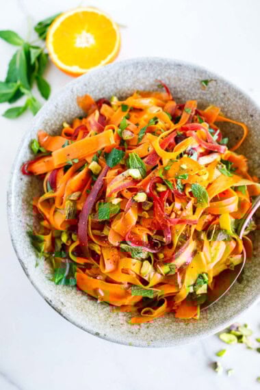 This Moroccan carrot salad is a light and refreshing side dish. Made with fresh carrots, herbs, pistachio nuts, dates, and an orange-cumin dressing. Vegan.