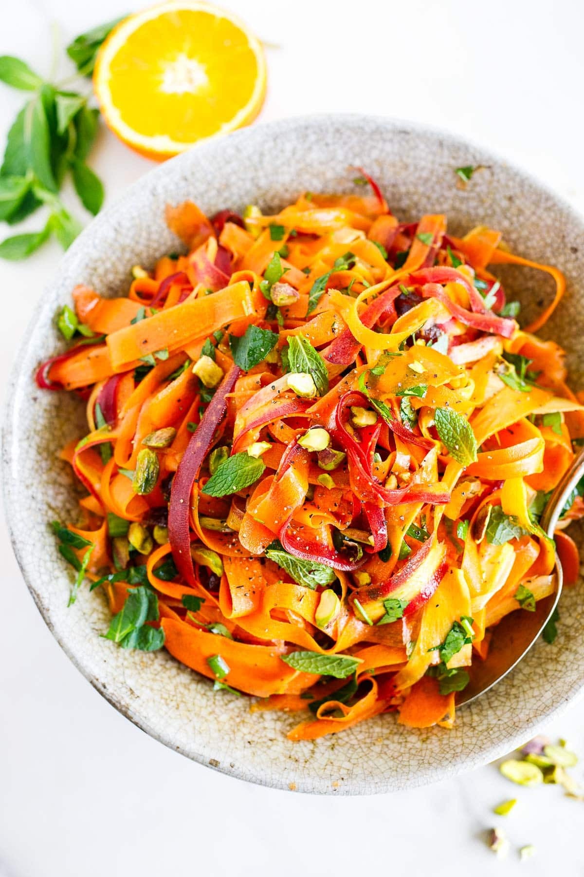 This Moroccan carrot salad is a light and refreshing side dish. Made with fresh carrots, herbs, pistachio nuts, dates, and an orange-cumin dressing. Vegan.