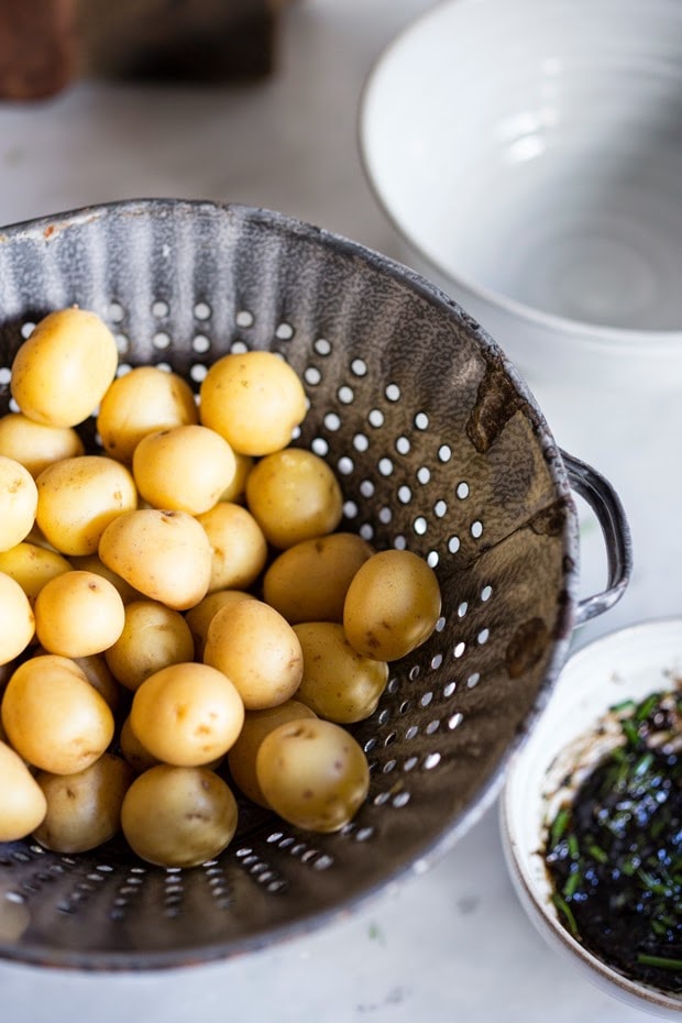 Grilled potato salad with a black garlic vinaigrette...a flavorful, lightened-up potato salad to serve alongside grilled meat or fish! Serve this warm or chilled.  #grilled #potatosalad #blackgarlic #healthypotatosalad #vegan