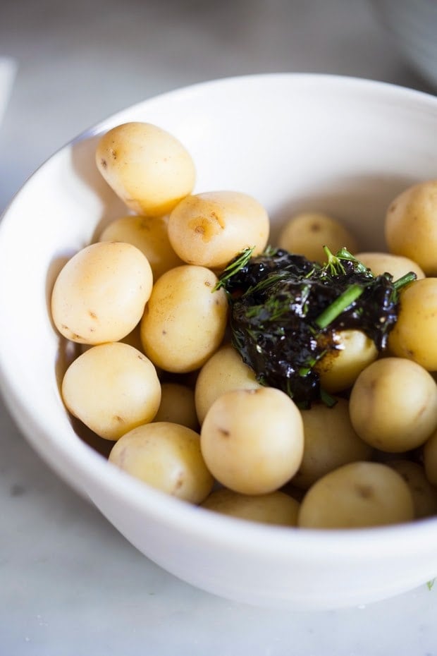 Grilled potato salad with a black garlic vinaigrette...a flavorful, lightened-up potato salad to serve alongside grilled meat or fish! Serve this warm or chilled.  #grilled #potatosalad #blackgarlic #healthypotatosalad #vegan