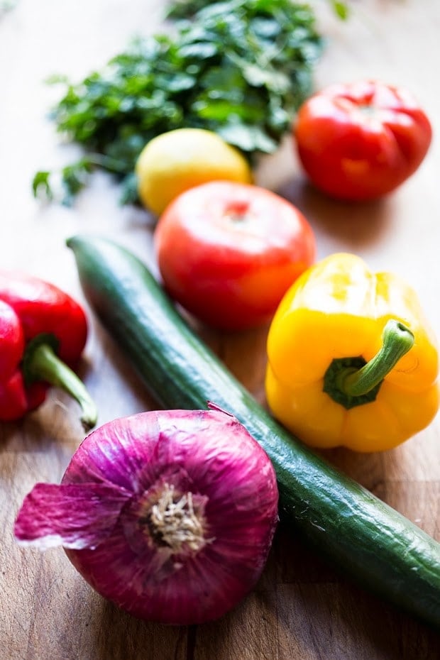 A simple & delicious recipe for Israeli Salad, made with finely chopped vegetables, fresh herbs, lemon and olive oil. Vegan and Gluten Free! | www.feastingathome.com