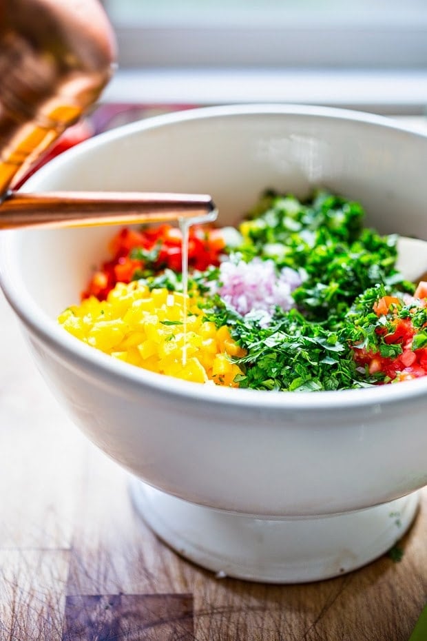 A simple & delicious recipe for Israeli Salad, made with finely chopped vegetables, fresh herbs, lemon and olive oil. Vegan and Gluten Free! | www.feastingathome.com