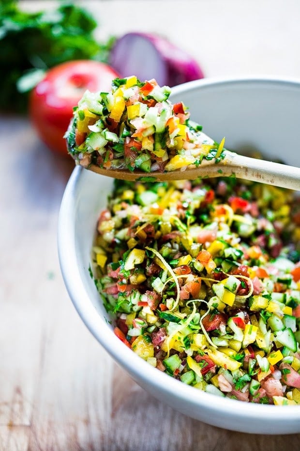 A simple & delicious recipe for Israeli Salad, made with finely chopped vegetables, fresh herbs, lemon and olive oil. Vegan and Gluten Free! | www.feastingathome.com