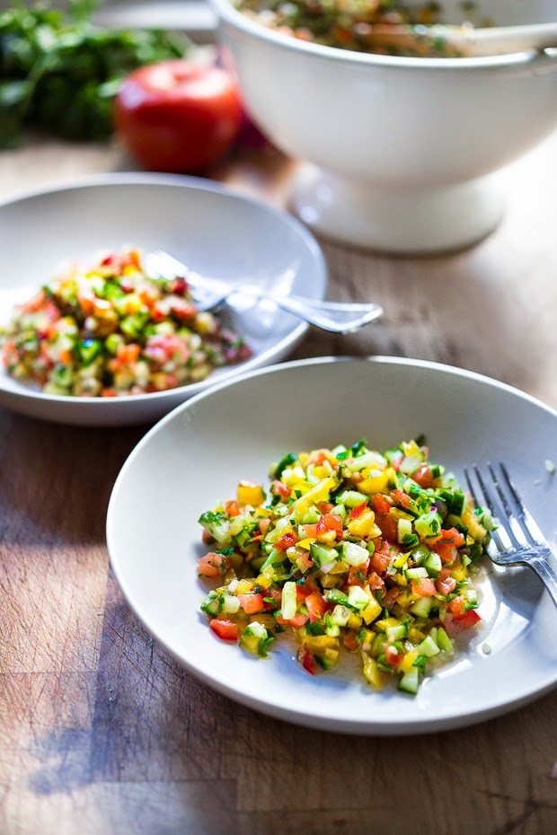 A simple & delicious recipe for Israeli Salad, made with finely chopped vegetables, fresh herbs, lemon and olive oil. Vegan and Gluten Free! | www.feastingathome.com
