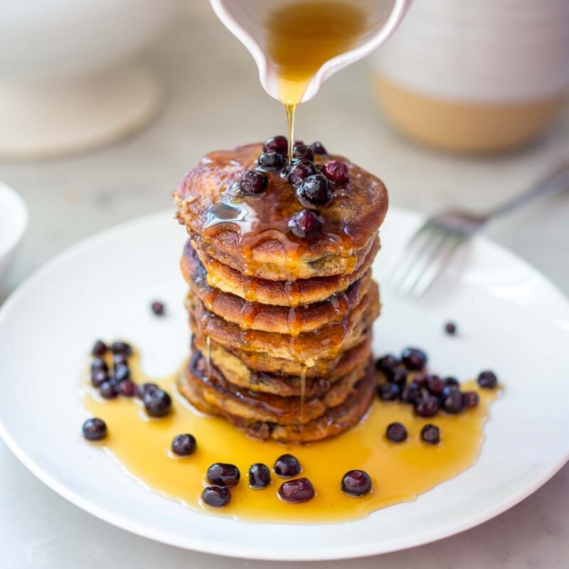 Almond flour pancakes with huckleberries and maple syrup.