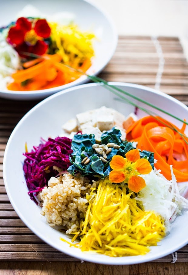 Vegan Sunshine Bowl w/ fresh crunchy veggies- grated beets, carrots, kohlrabi, sunchokes, radish & jicama with nutty brown rice and sunflower tahini sauce. | www.feastingathome.com