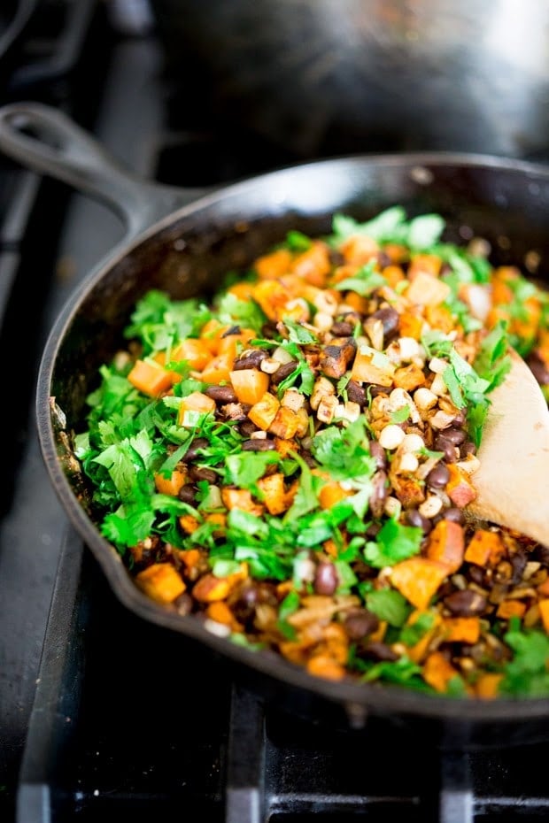 Vegan stuffed poblano peppers filled with sweet potatoes, black beans, corn and cilantro - served over the best thing ever - a flavorful Avocado-Cilantro Sauce which is vegan and has no other added oils or fat. | www.feastingathome.com