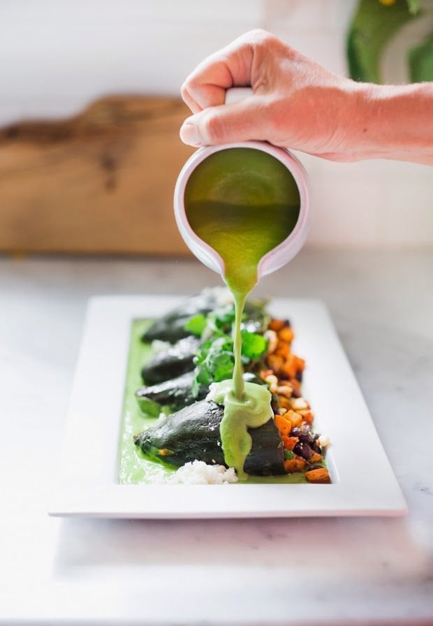 Vegan, Oil-Free Avocado Sauce poured over vegan stuffed Poblanos | www.feastingathomcome