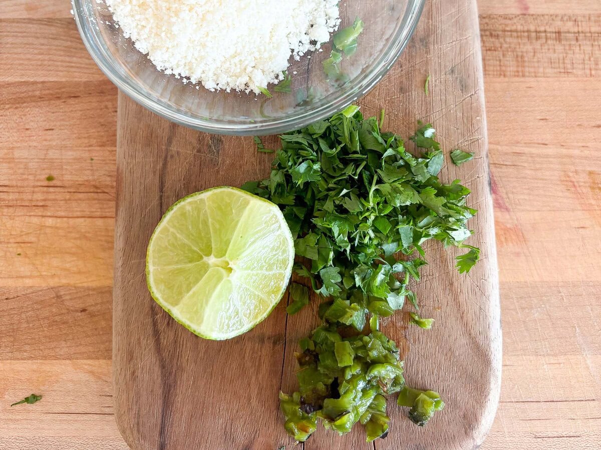 garnishes for corn soup: cilantro, lime, jalapeno, charred jalapeno and cotija cheese.