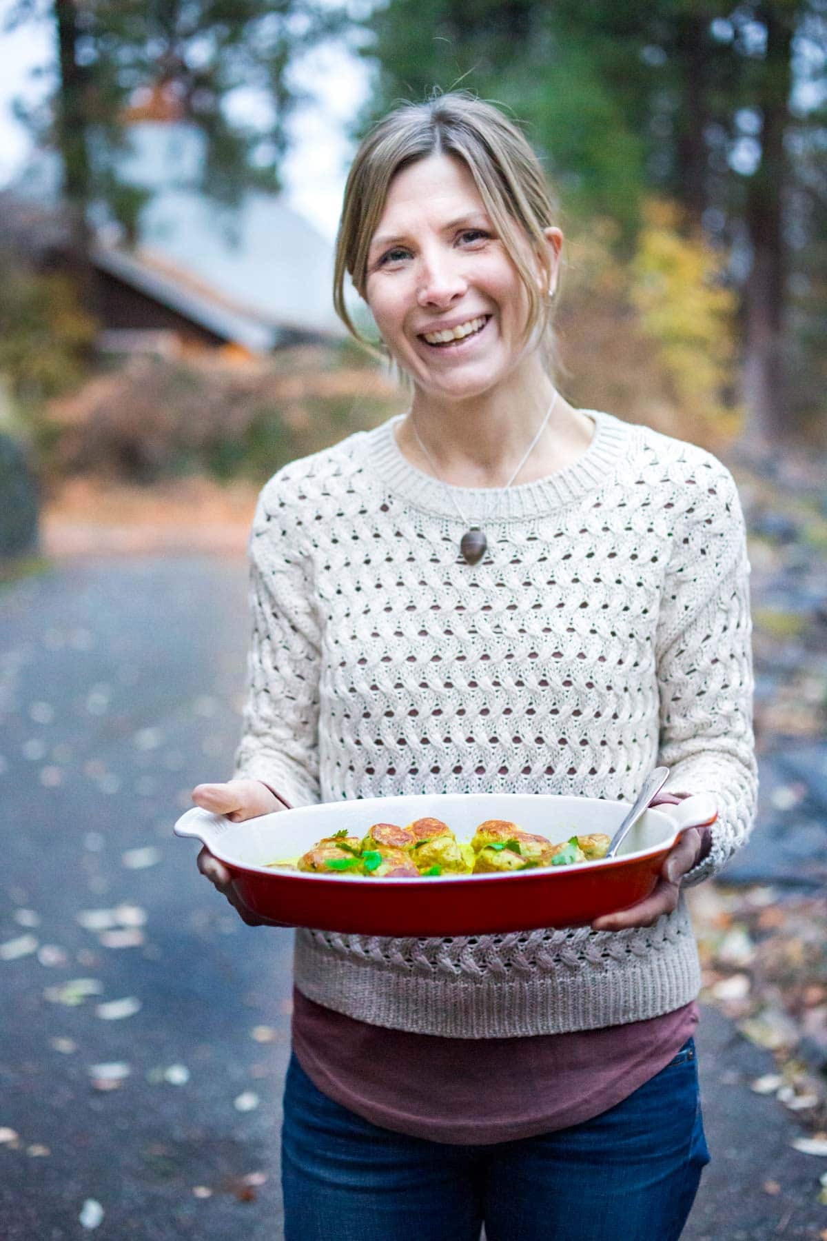 Maryann holding a serving dish with thai turkey meatballs.