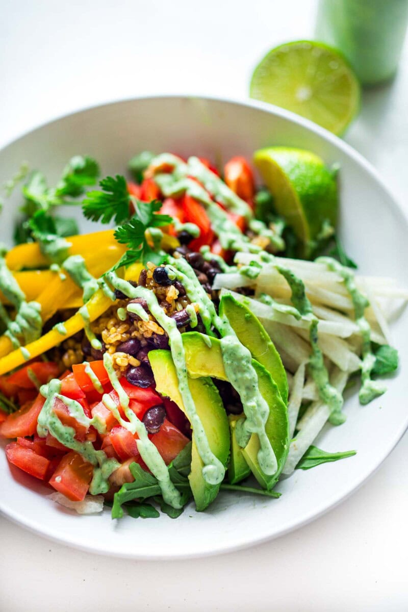 This Burrito bowl recipe is way better than Chipotle takeout! Made with rice and beans and fresh, healthy veggies, it's easy, adaptable and full of flavor! Perfect for meal prepping, vegan, vegetarian, gluten-free. 