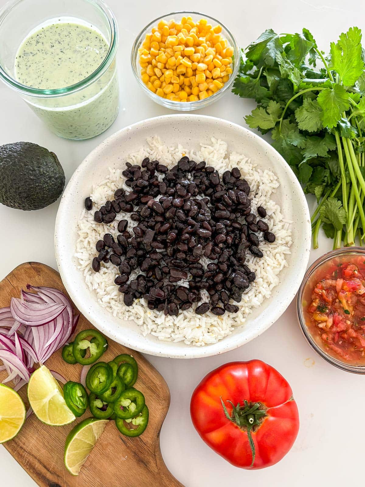 Assembling the burrito bowl- rice and beans in a wide shallow bowl.