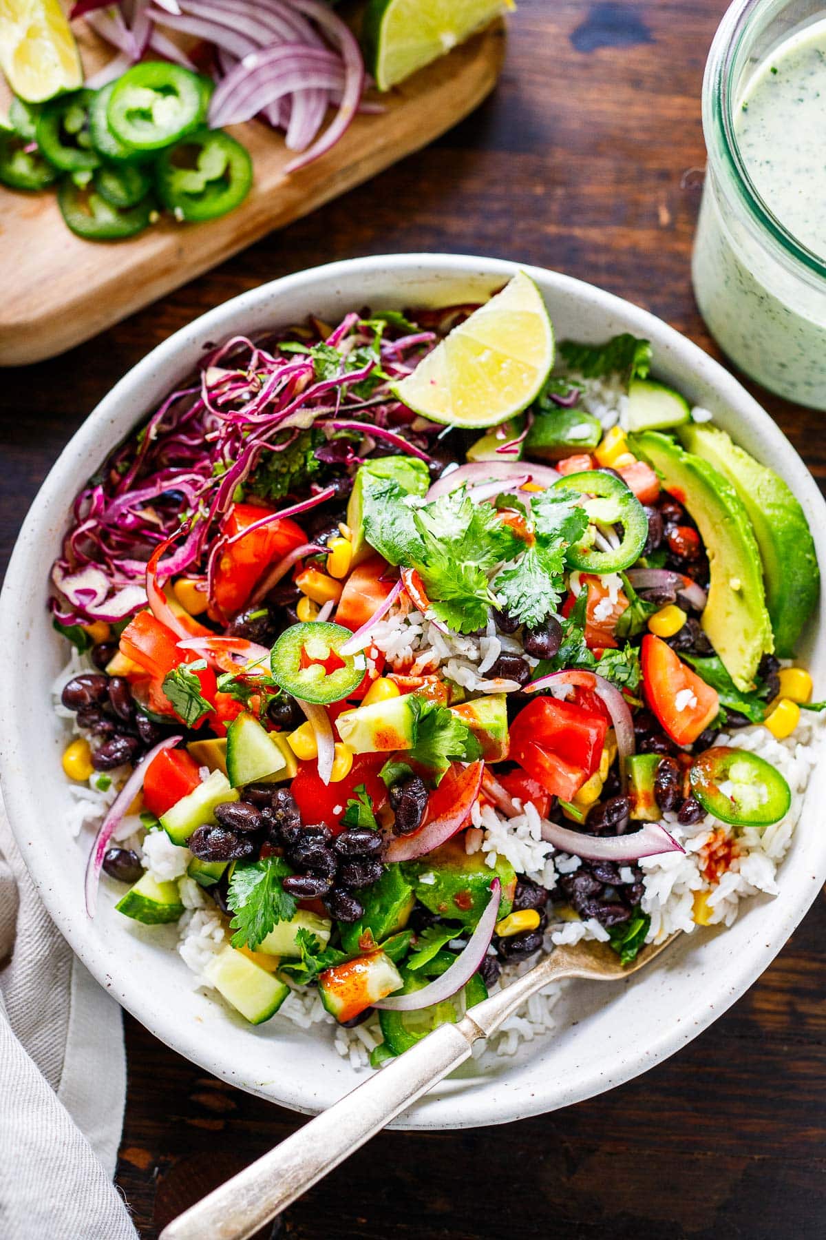burrito bowl with black beans rice, tomatoes, jalapeno, avoaco, cabbage, and lime.