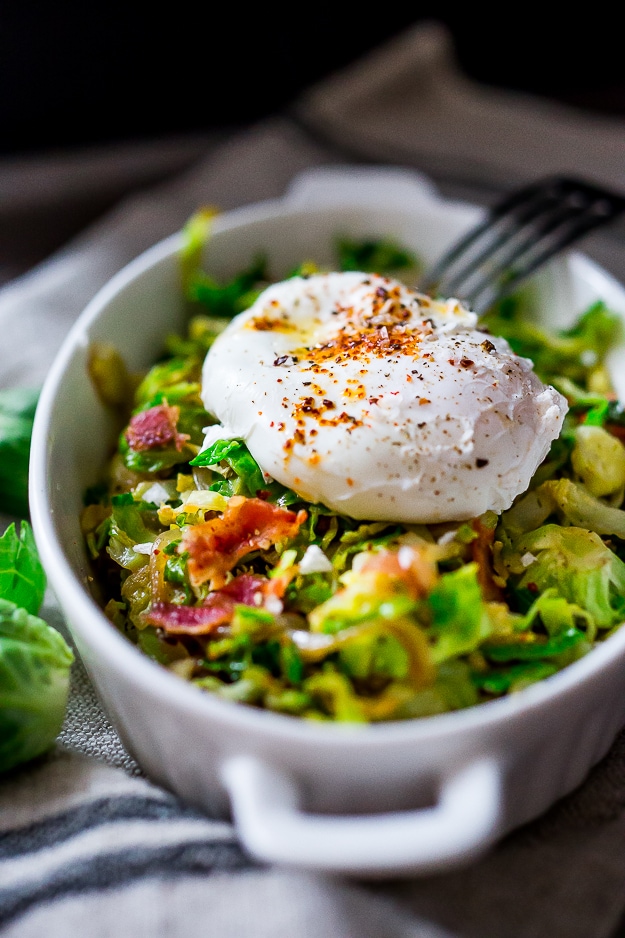 Brussel Sprout Hash with Soft Poached Egg and Aleppo Chili Pepper A delicious low-carb breakfast- Brussels sprouts and bacon hash topped with soft pillowy poached eggs. Bacon is optional. See recipe notes for alternatives!