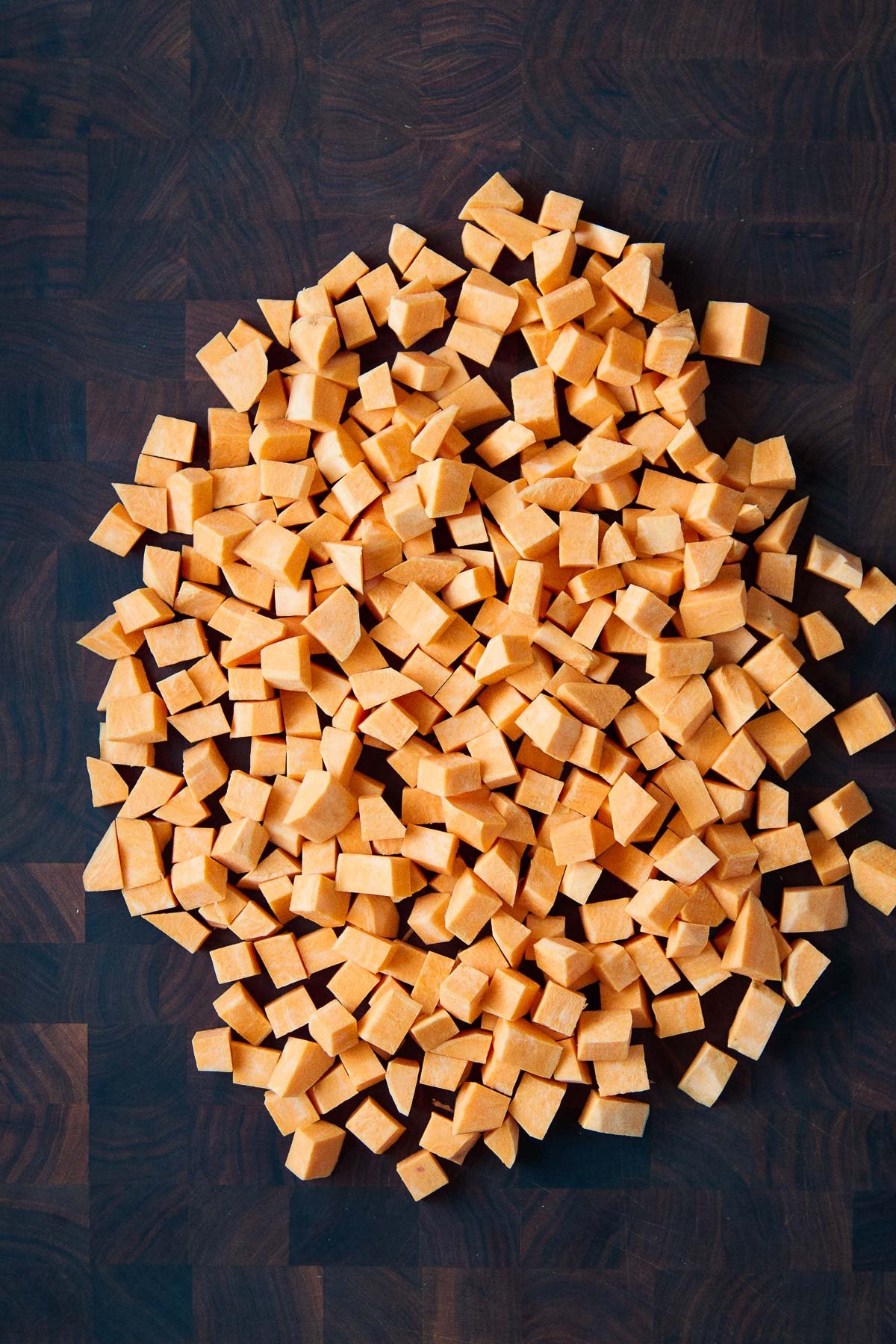 diced one-inch sweet potato cubes on wood butcher block. 