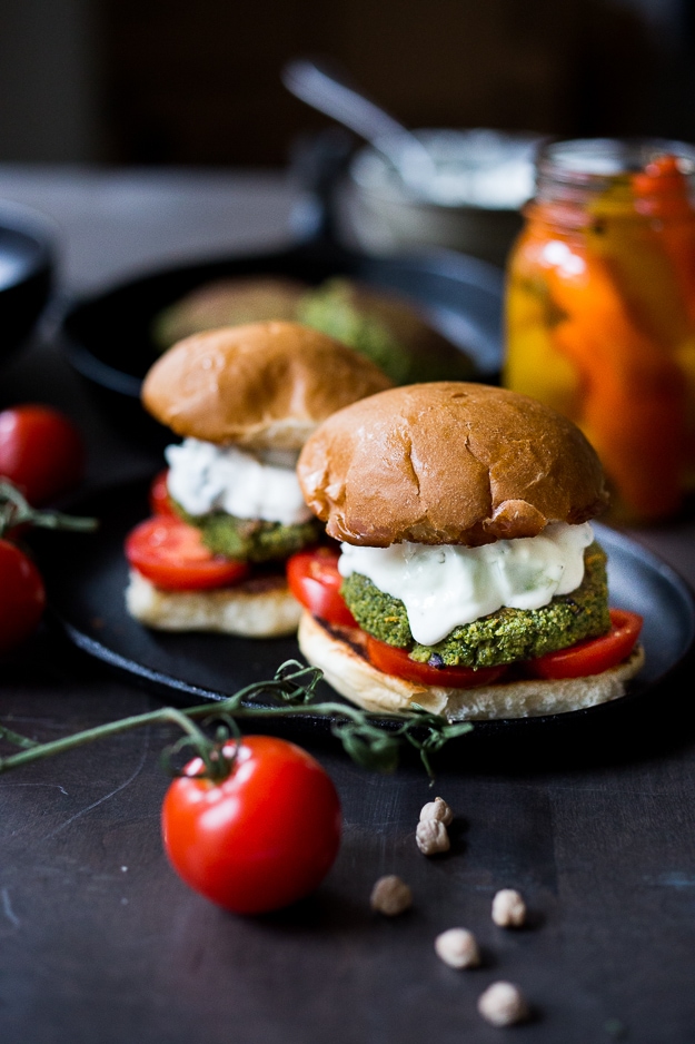 Falafel Burgers with Tzatziki Sauce! These vegan burgers get a Middle Eastern twist- healthy, delicious and full of amazing flavor. #falafelburgers #veganfalafel #veganburger #falafelburger | www.feasitngathome.com