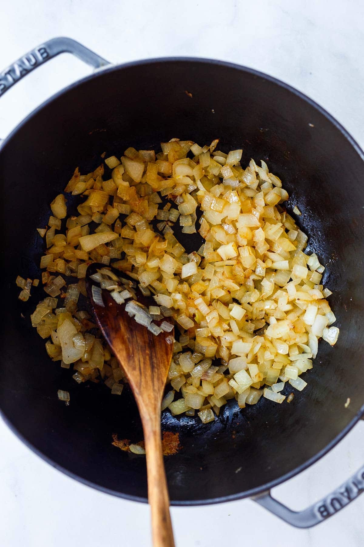 diced onions sautéing in Dutch oven.