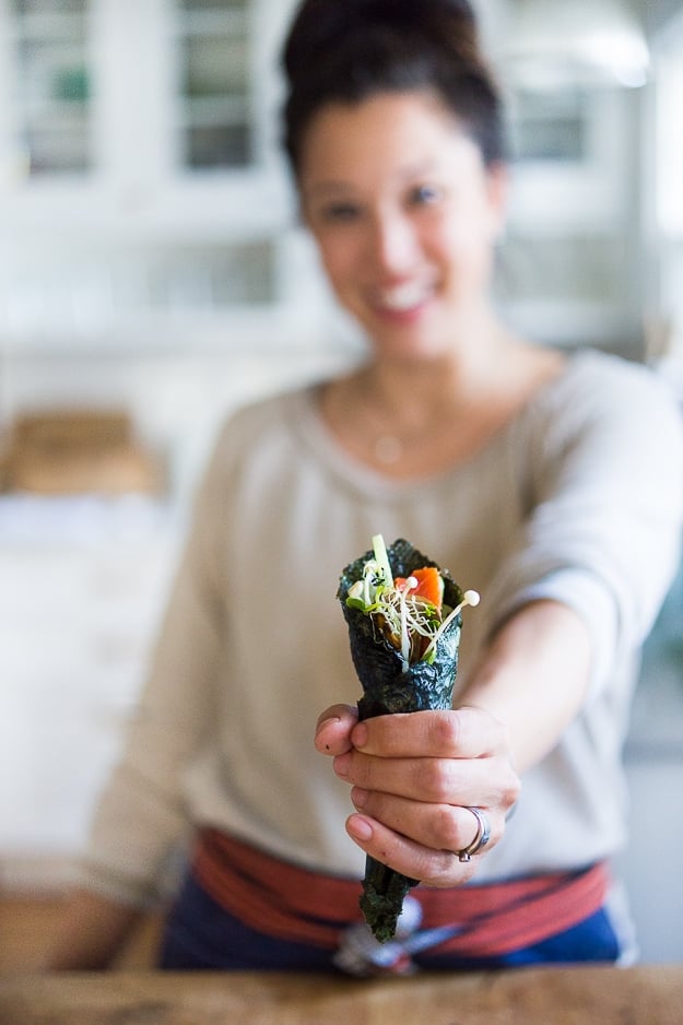 Nami Meier and her Healthy Smoked Salmon Hand rolls filled with avocado, cucumber and smoked salmon...an affordable fun way to feed a large gathering! | www.feastingathome.com