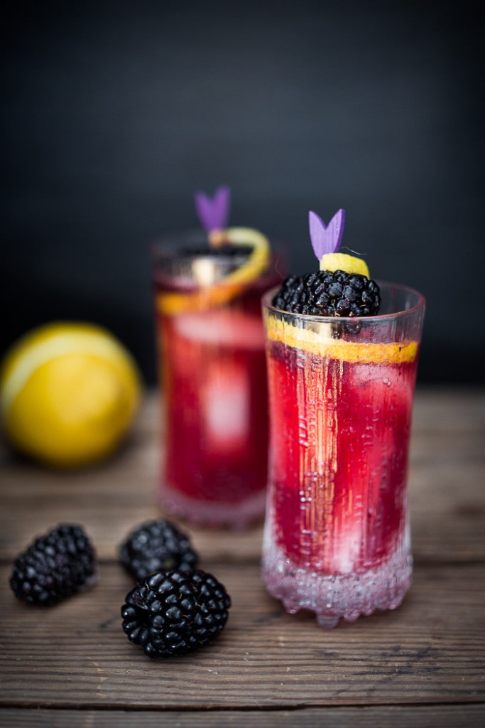 A refreshing summer drink, The Blackberry Bramble, featuring fresh muddled blackberries, gin, lemon juice and soda or ginger beer | www.feastingathome.com