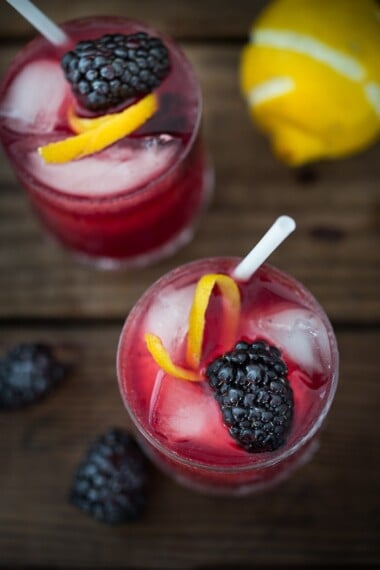 A refreshing summer cocktail called the Blackberry Bramble with muddled fresh blackberries, gin, lemon juice and soda or ginger brew! | www.feastingathome.com