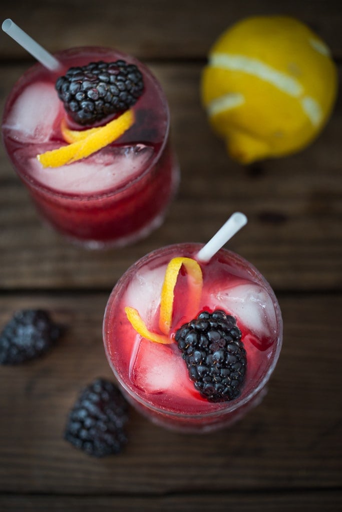 A refreshing summer drink, The Blackberry Bramble, featuring fresh muddled blackberries, gin, lemon juice and soda or ginger beer | www.feastingathome.com
