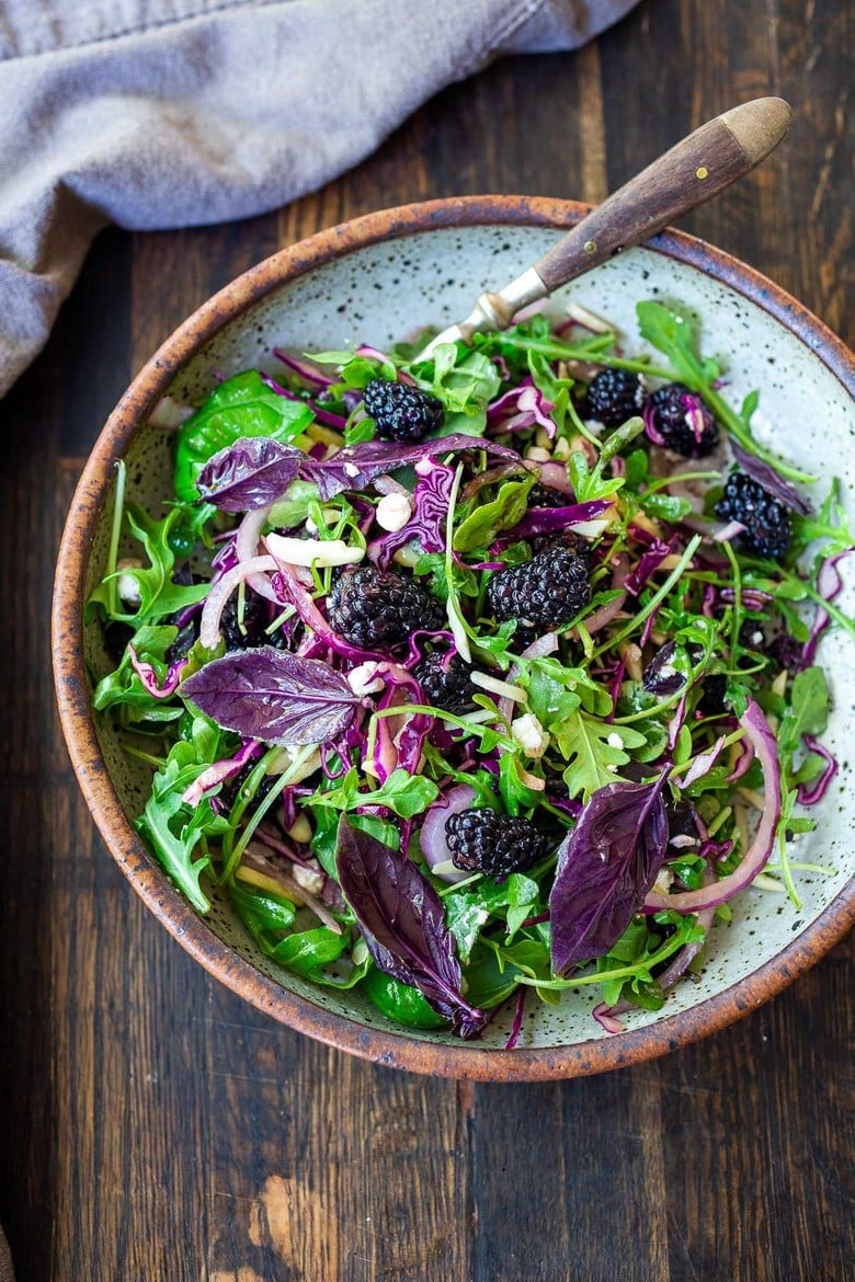 A simple recipe for Blackberry Salad with Basil and Arugula sprinkled with crumbled goat cheese, toasted almonds and a maple-balsamic dressing. A light and delicious summer salad! #blackberry #blackberrysalad