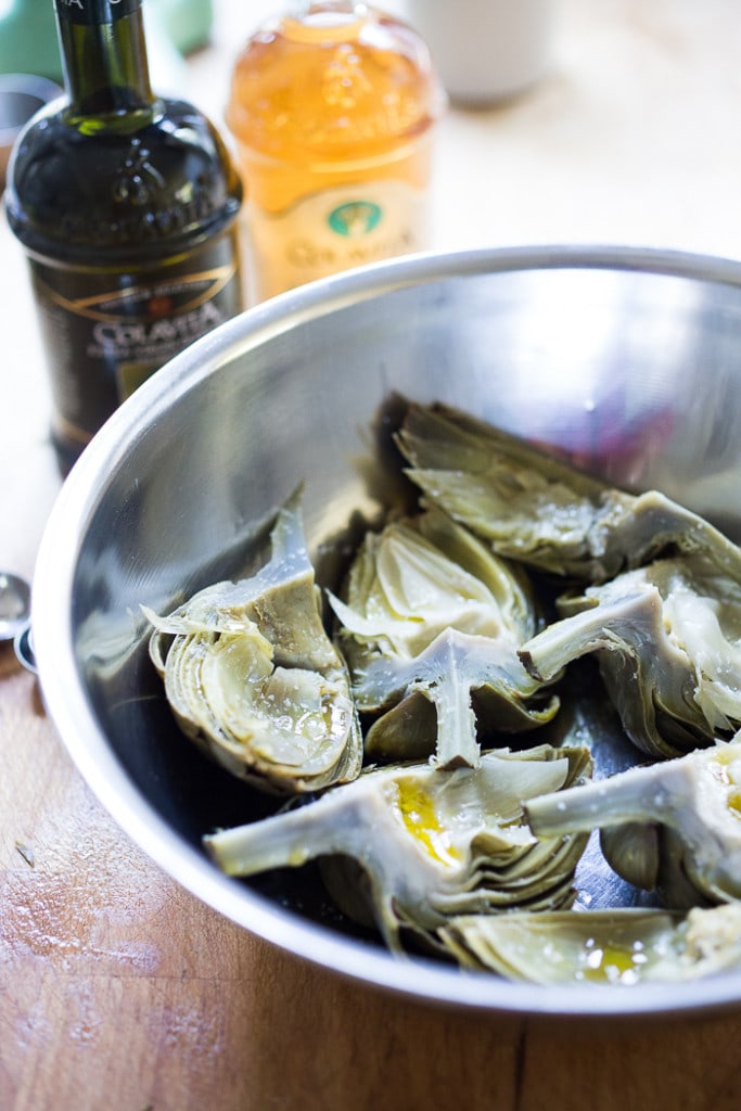 Grilled Artichokes and Polenta with Blistered tomatoes, pesto, capers and fresh basil-- served family style ...perfect for a casual summer evening! Vegan and GF | www.feastingathome.com| #grilledartichokes