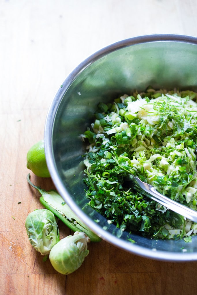 Vegan Mexican Brussel Sprout Salad with jalapeño, lime and cilantro! Serve as a "taco slaw",  a side salad for grill mains or meats. This salad can be made ahead! #brusselsproutsalad #brusslesproutslaw #brusselsprouts #veganslaw #vegansalad #mexicanslaw