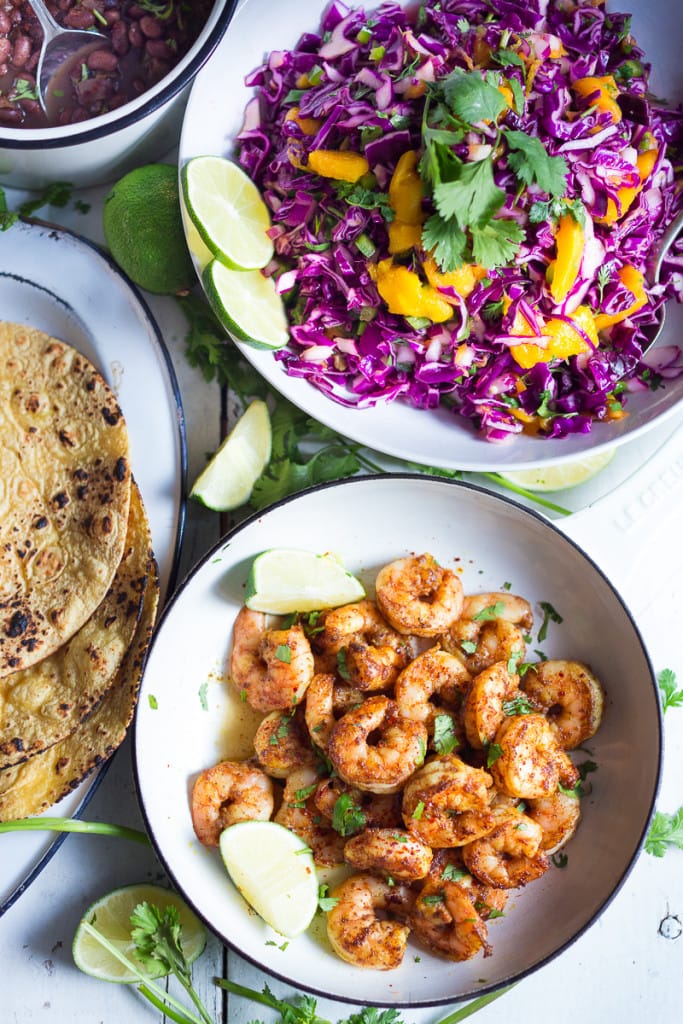 The BEST Shrimp Tacos with a Mango Cabbage Slaw- bursting with Caribbean flavors! Healthy, easy and fast- and can be made in 30 mins!| #shrimptacos #bestshrimptacos #shrimp #mango #cabbageslaw #tacos #mangosalad #blackbeantacos #prawntacos 