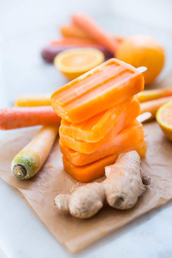 This refreshing and healthy Popsicle Recipe is made with fresh carrot & orange juice with a hint of Ginger and Turmeric- incredibly delicious with no sugar added! 