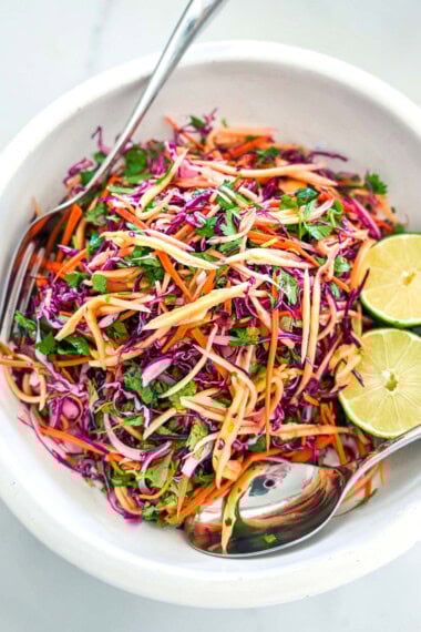 This mango slaw recipe is so refreshing and light! Made with fresh mango, crunchy purple cabbage, red onion, cilantro, and lime, this salad is the perfect summer treat and makes a delicious topping for tacos, bowls, and more!