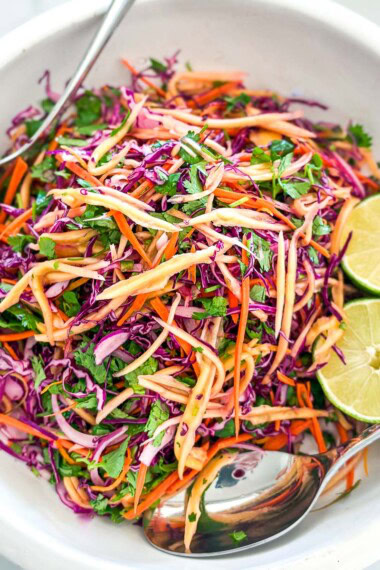 This mango slaw recipe is so refreshing and light! Made with fresh mango, crunchy purple cabbage, red onion, cilantro, and lime, this salad is the perfect summer treat and makes a delicious topping for tacos, bowls, and more!