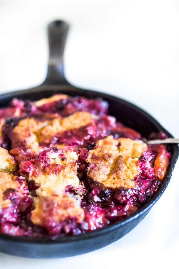 A crispy crumbly biscuit topped skillet cobbler with fresh summer peaches and optional huckleberries. Use other summer berries, like black berries or blueberries! This can be made gluten-free and or vegan! 