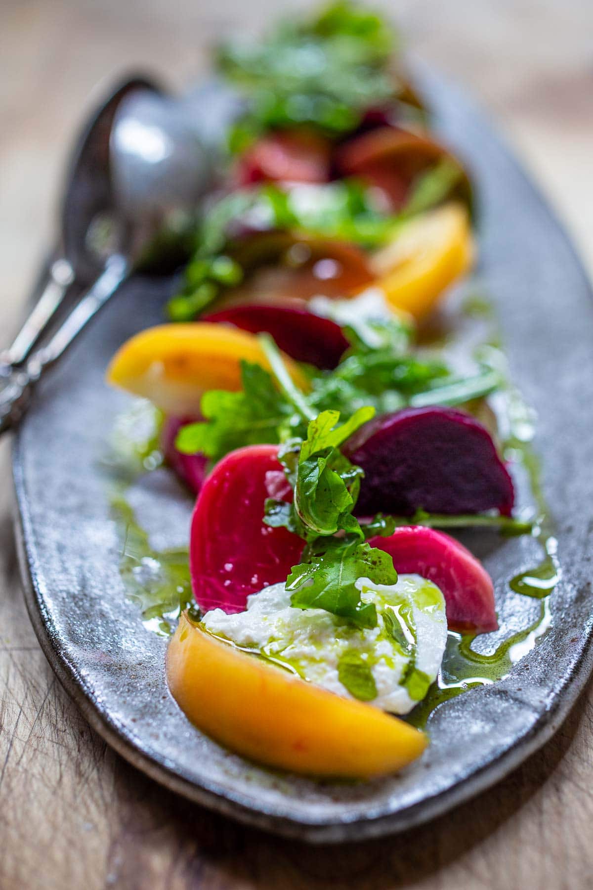 A beautiful Burrata Salad with tomatoes, beets, basil and flavorful basil oil, drizzled with balsamic glaze - perfect for summer dinners and gatherings. Elegant and flavorful.