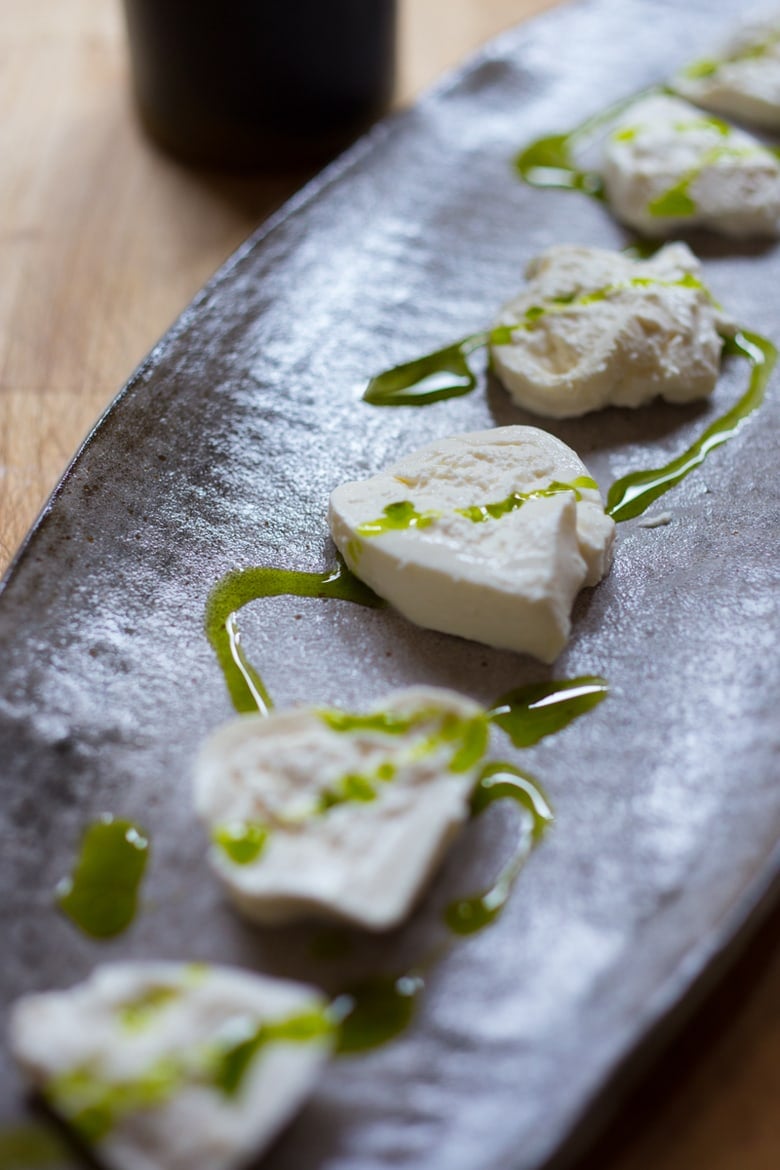 drizzling basil oil over the burrata cheese.