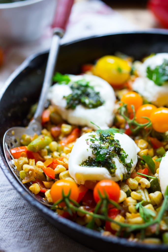 Breakfast Succotash with zucchini, corn and peppers, topped with poached eggs and a flavorful herb oil. | www.feastingathome.com