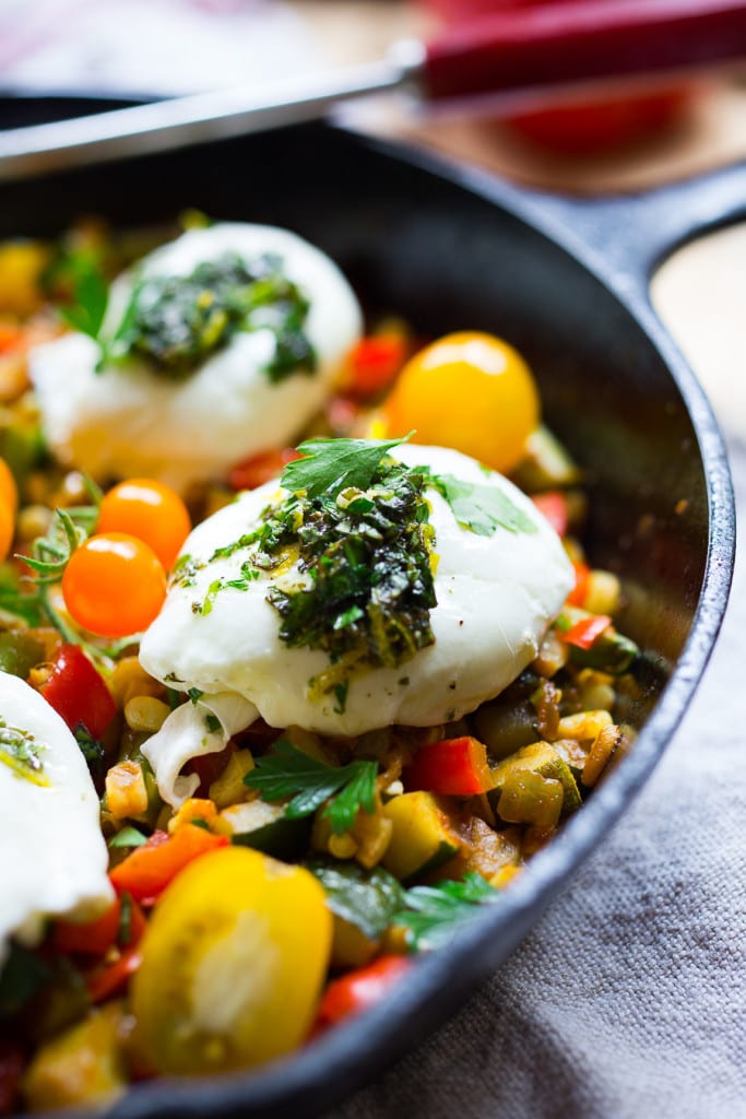 Breakfast Succotash with zucchini, corn and peppers, topped with poached eggs and a flavorful herb oil. | www.feastingathome.com