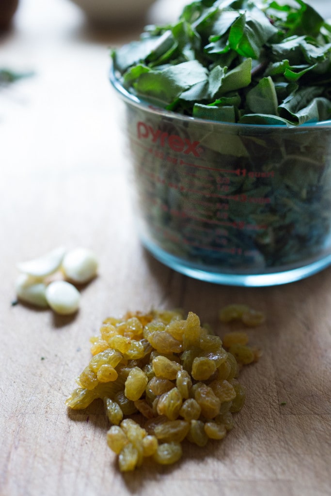 ingredients in sautéed spinach showing golden raisins, aka sultanas.
