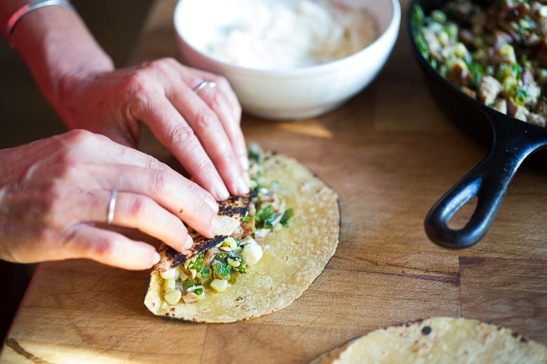 How to stuff enchiladas! Enchiladas Verde with Corn, Chicken ( or Black beans) and Roasted Poblano Sauce. A simple healthy Mexican inspired meal that is easy and flavorful! #enchiladasverde #greenenchiladas #enchiladas #poblanosauce #greensauce #mexicangreensauce #tomatillosauce #chickenenchiladas #vegetarianenchiladas 