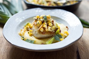 A delicious recipe for seared Halibut, featuring fresh summer corn, leeks, sage and optional pancetta served over creamy polenta.