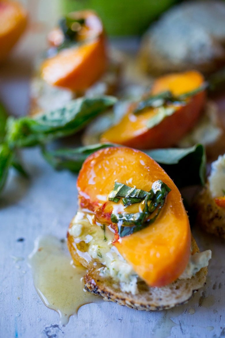 Peach bruschetta with goat cheese, fresh basil and infused honey! A simple way to use fresh summer peaches in a savory way! #peaches #peachappetizer #summerappetizer #peachrecipes